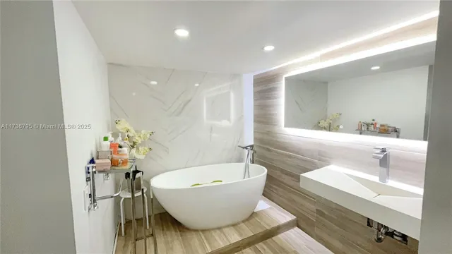 a bathroom with a bathtub a sink and a mirror