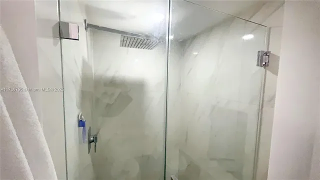 a bathroom with a shower and a glass door