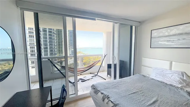 a bedroom with a bed and a flat tv screen next to a window