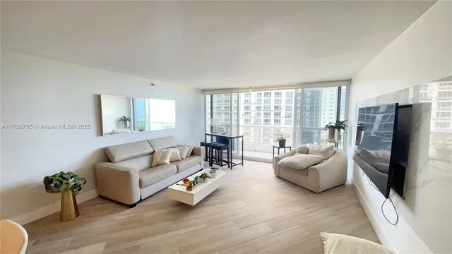 a living room with furniture flat screen tv and a large window