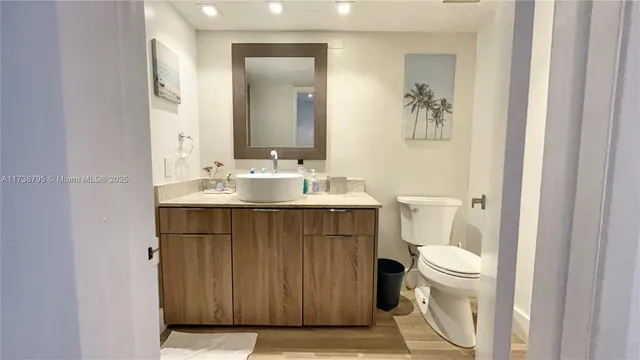 a bathroom with a sink vanity mirror and toilet