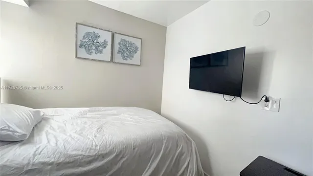 a bedroom with a bed and a flat screen tv