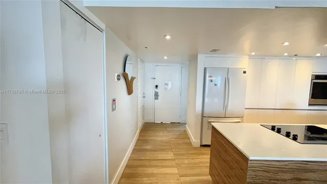 a hallway view with wooden floor and living room
