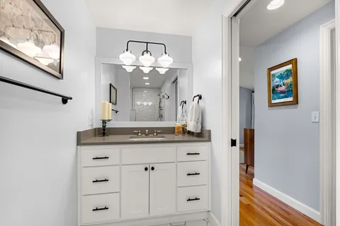 a bathroom with a granite countertop sink and a mirror