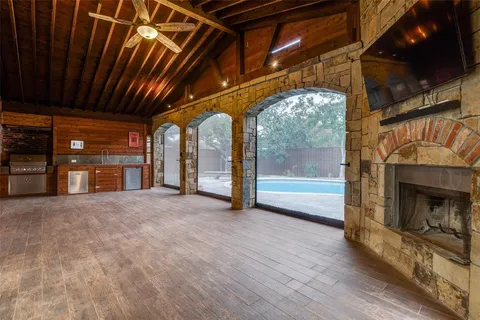a view of an empty room with wooden floor and a fireplace