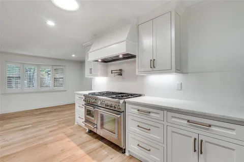 a stove top oven sitting inside of a kitchen