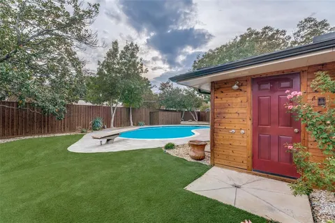 a view of a backyard with plants and wooden fence