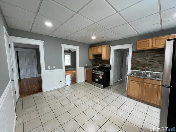 a large kitchen with a stove a sink dishwasher and a refrigerator