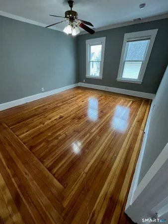 a view of an empty room with a chandelier fan