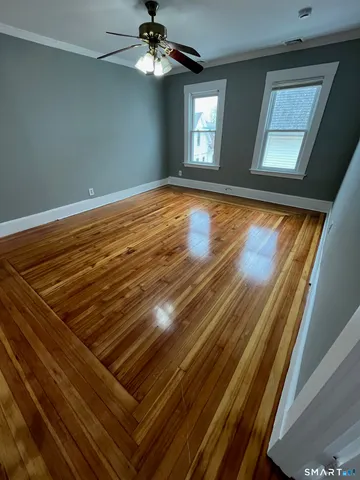 a view of an empty room with a chandelier fan