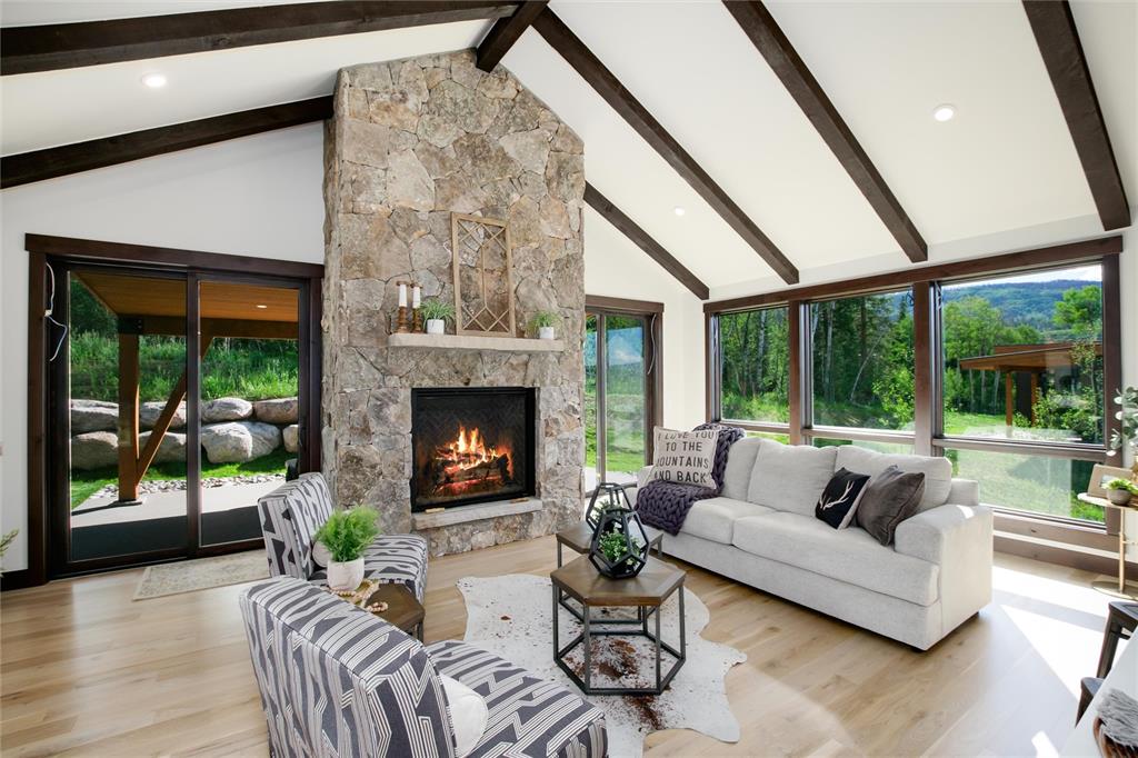 55 Glazer Trail Silverthorne, CO 80498 - Photo 7 of 35 a living room with furniture a fireplace and a floor to ceiling window