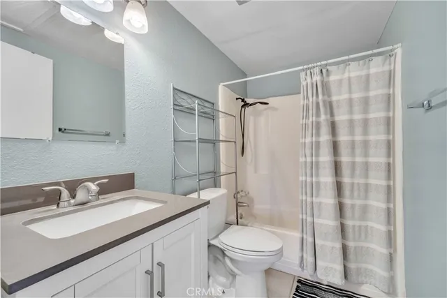 a bathroom with a sink toilet vanity and shower