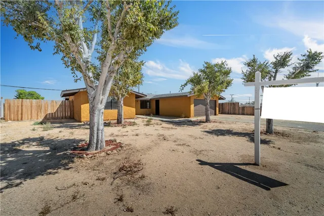 a front view of a house with a tree