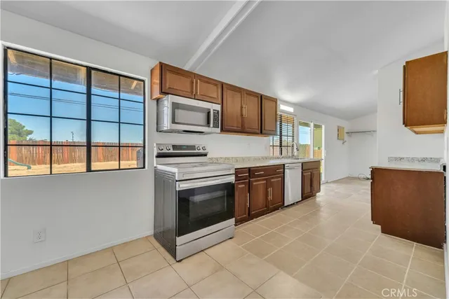 a kitchen with stainless steel appliances a stove a sink and a microwave
