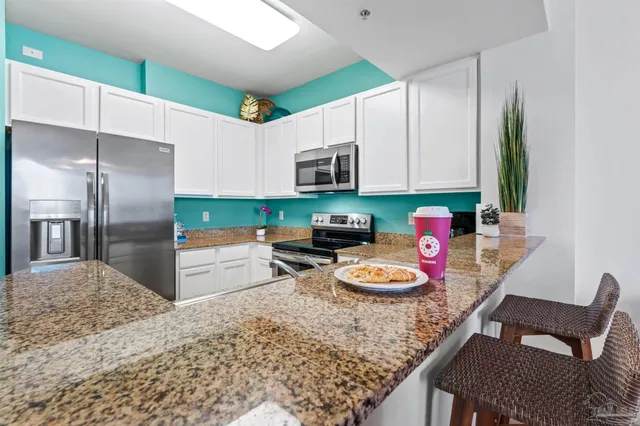 a kitchen with stainless steel appliances granite countertop a refrigerator and a stove top oven