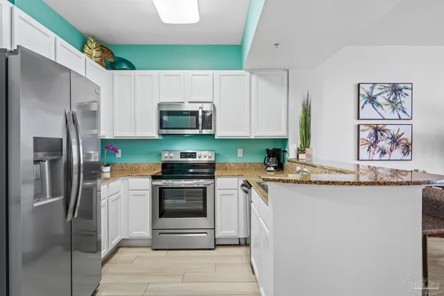 a kitchen with stainless steel appliances a stove microwave and a refrigerator