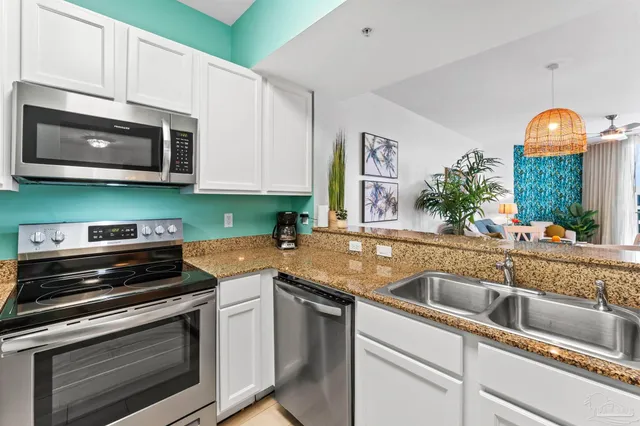 a kitchen with stainless steel appliances granite countertop a sink and a stove