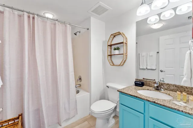 a bathroom with a granite countertop sink toilet and a mirror