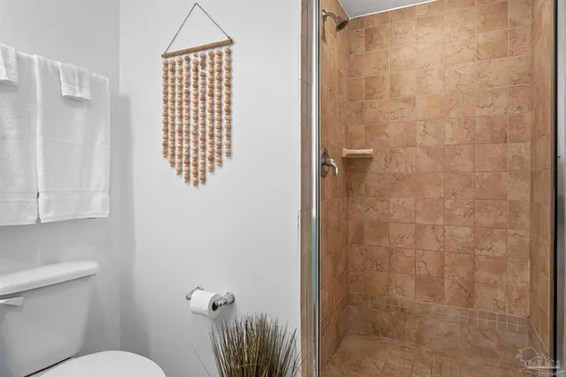 a bathroom with a toilet and a shower