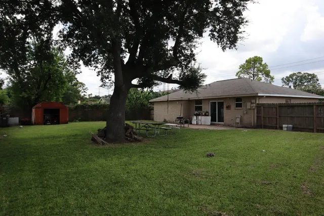a backyard of a house with table and chairs
