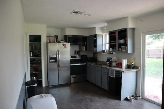a kitchen with stainless steel appliances a refrigerator a sink a stove and cabinets