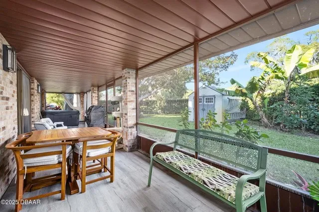 a view of a backyard with potted plants and large tree