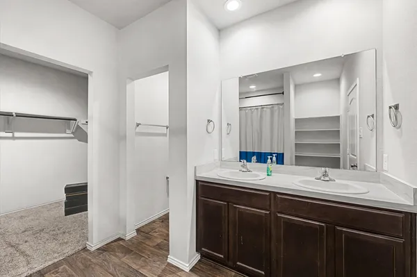 a bathroom with a double vanity sink a mirror and a shower