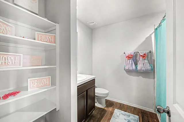 a bathroom with a toilet and a shower curtain