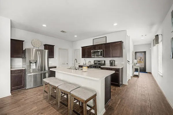 a large kitchen with a table and refrigerator