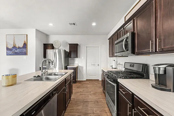 a kitchen with stainless steel appliances granite countertop a sink stove and refrigerator