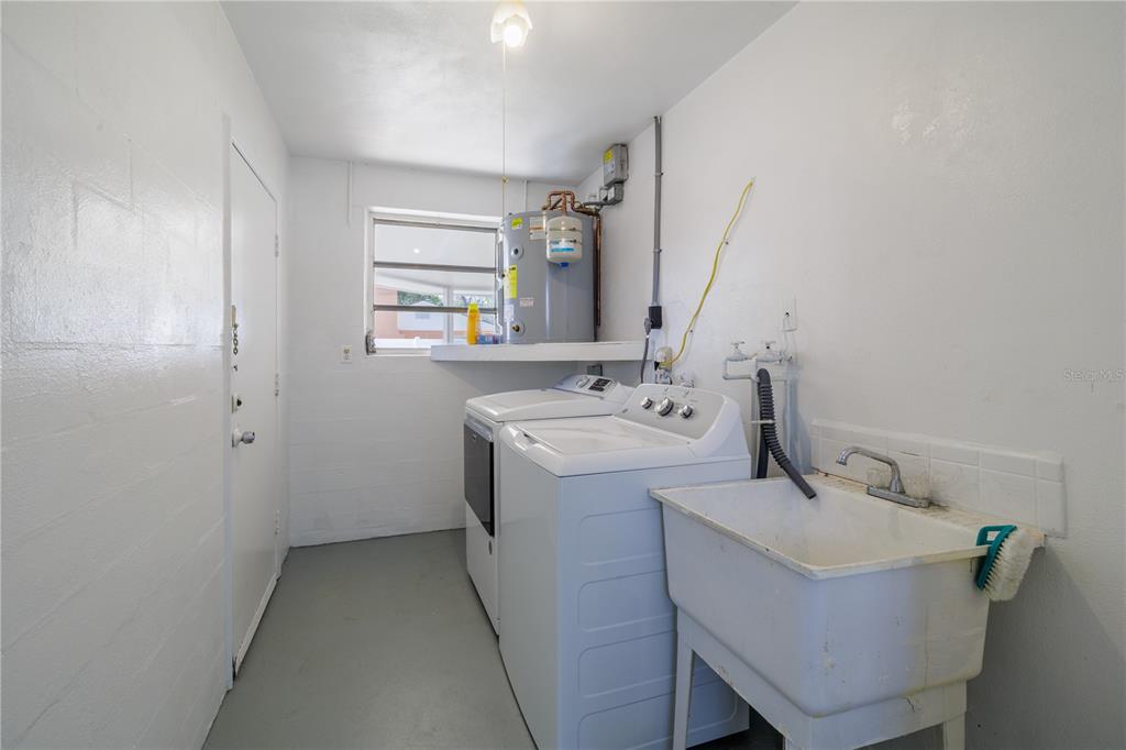 1016 Cherokee Ranch Road Holly Hill, FL 32117 - Photo 17 of 23 a utility room with a sink washer and dryer