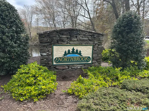 a sign that is sitting in front of flowers