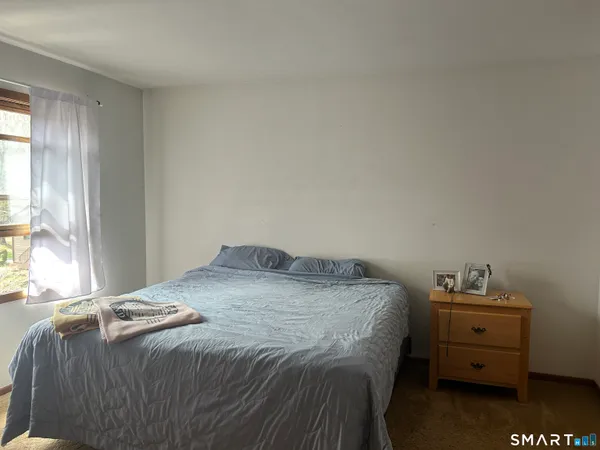 a bedroom with a bed and window