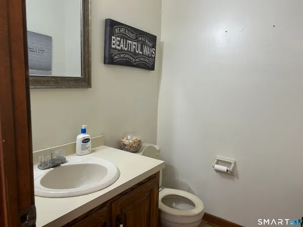 a bathroom with a sink vanity mirror and toilet