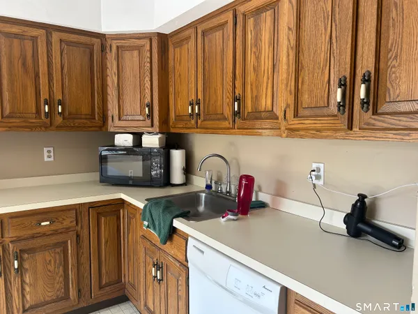 a kitchen with stainless steel appliances granite countertop a sink a stove and white cabinets with wooden floor