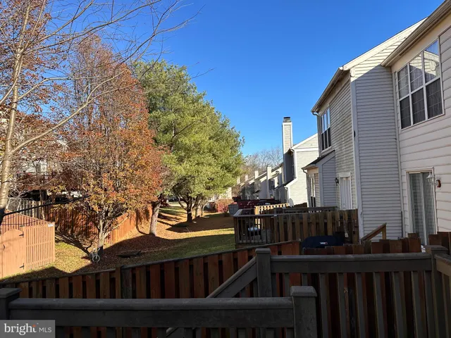 a view of a street with wooden fence and trees