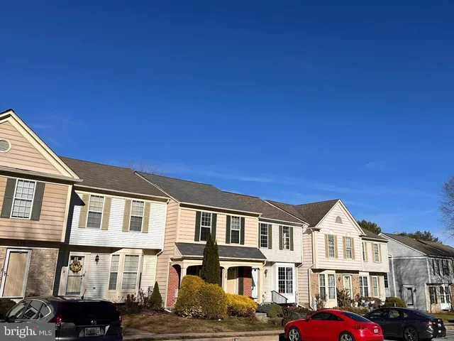 a front view of residential houses with cars parked