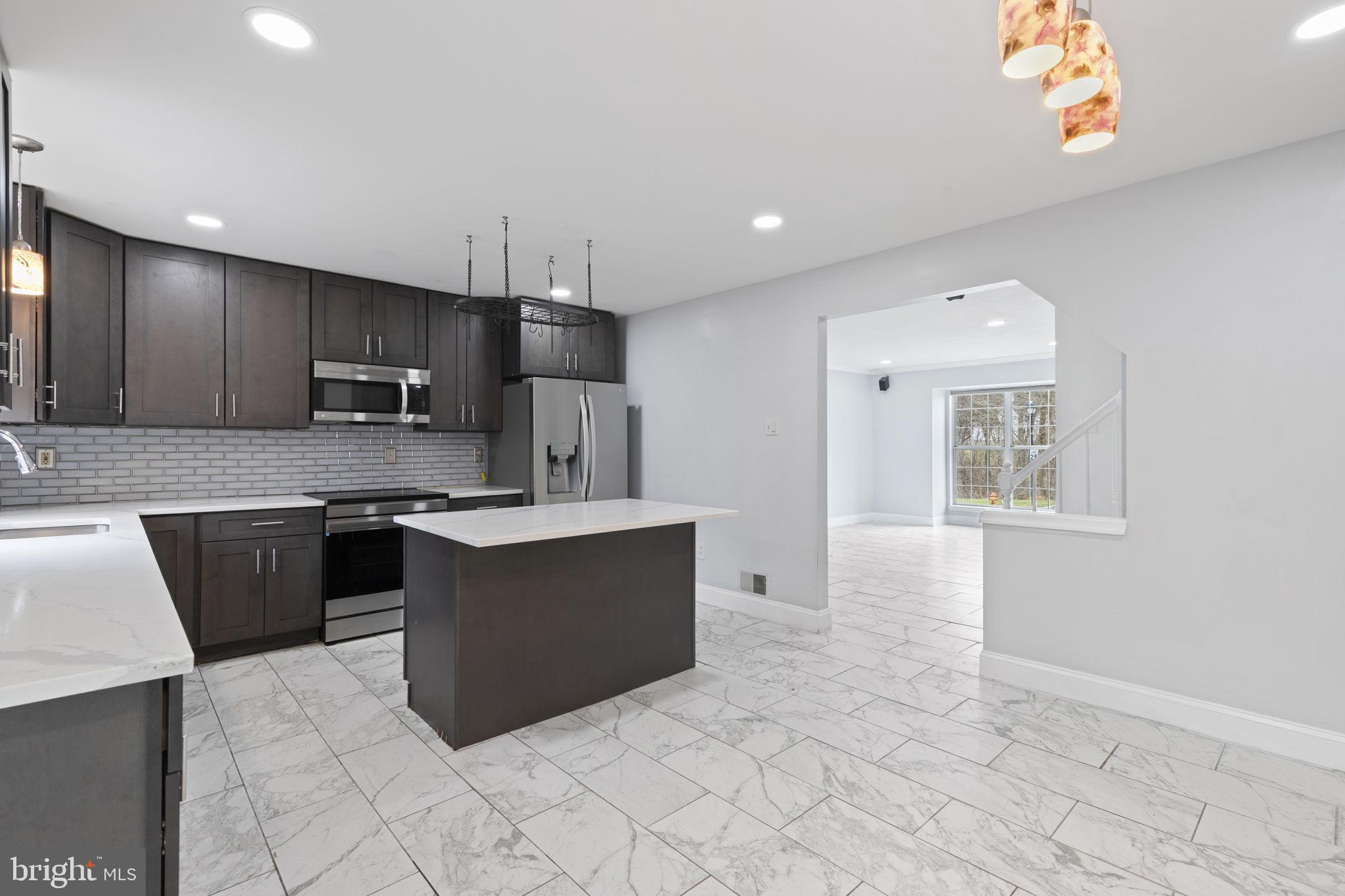 126 Gentlebrook Road Owings Mills, MD 21117 - Photo 8 of 30 a large kitchen with kitchen island granite countertop a sink a counter top space and cabinets