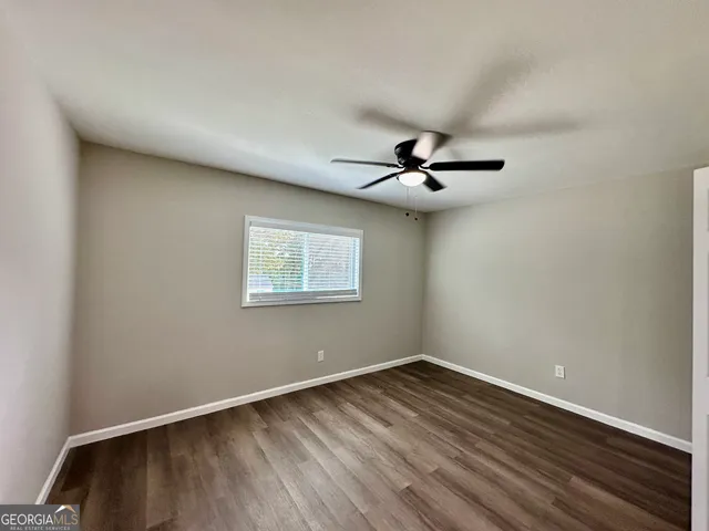 a view of a room with wooden floor and fan