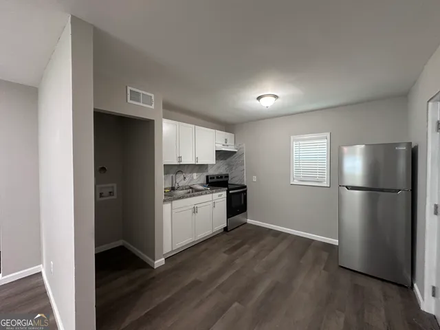 a kitchen with a refrigerator and a stove top oven