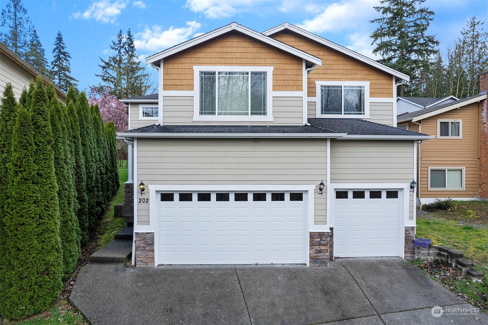 202 199th Street Southwest Bothell, WA 98012 - Photo 1 of 30 a view of a white house with large windows and a small yard