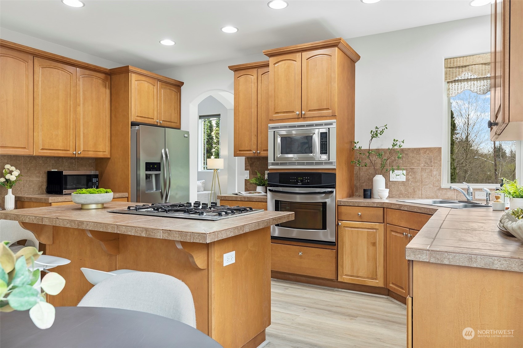 202 199th Street Southwest Bothell, WA 98012 - Photo 8 of 30 a kitchen with stainless steel appliances granite countertop a stove top oven a sink dishwasher and a refrigerator with wooden floor
