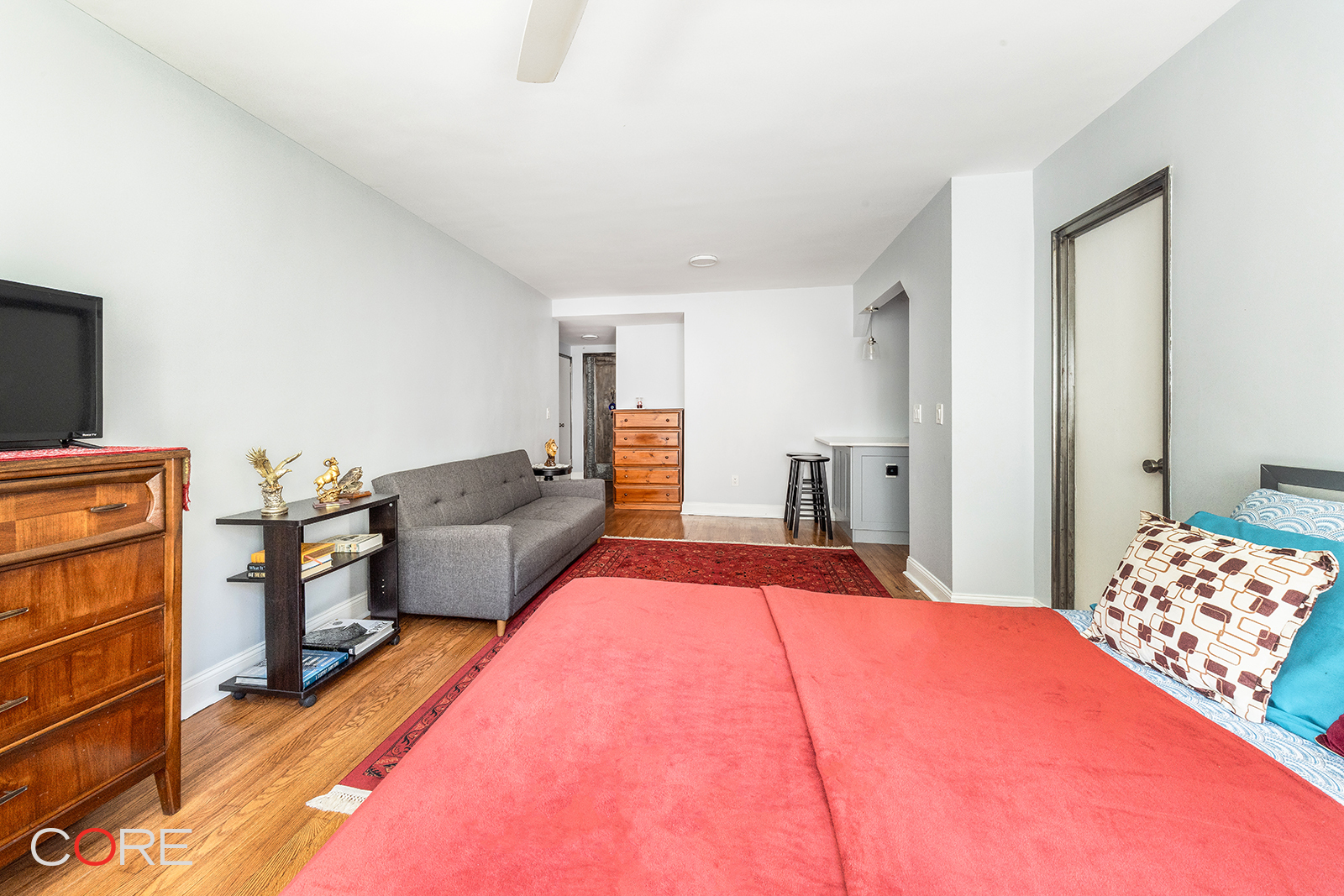 35-21 79th Street, Unit 1L Queens, NY 11372 - Photo 3 of 8 a bedroom with a bed and dresser with mirror