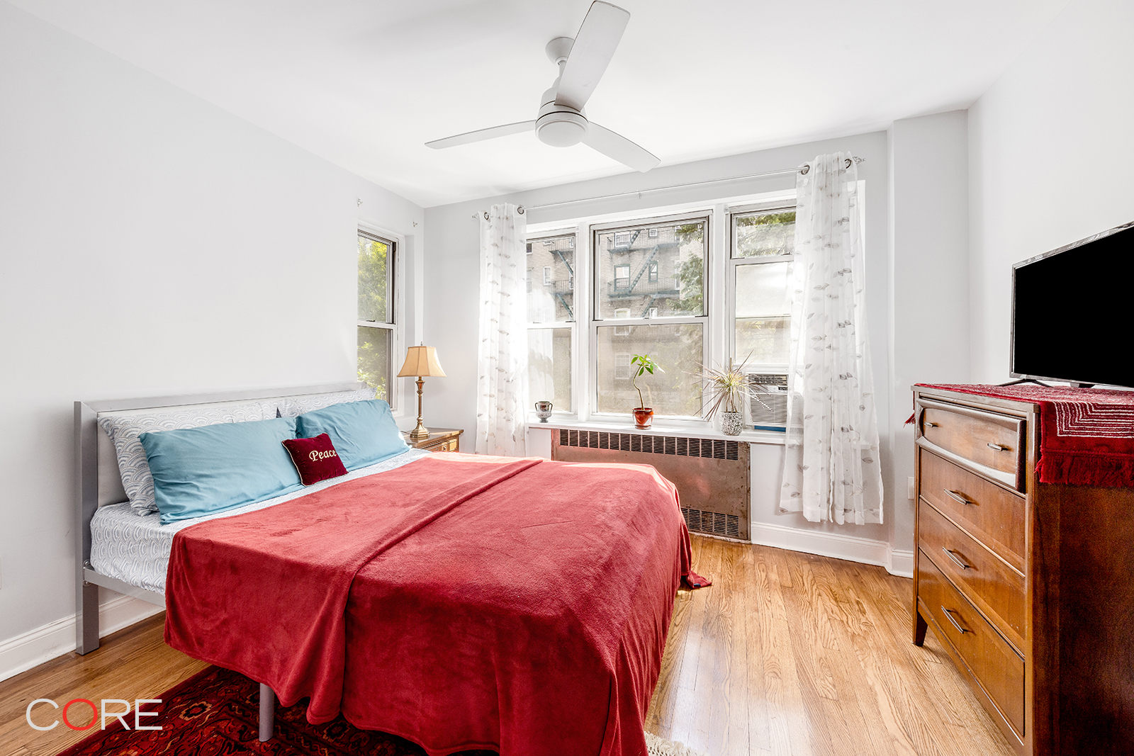 35-21 79th Street, Unit 1L Queens, NY 11372 - Photo 5 of 8 a bedroom with a bed and a flat tv screen on dresser