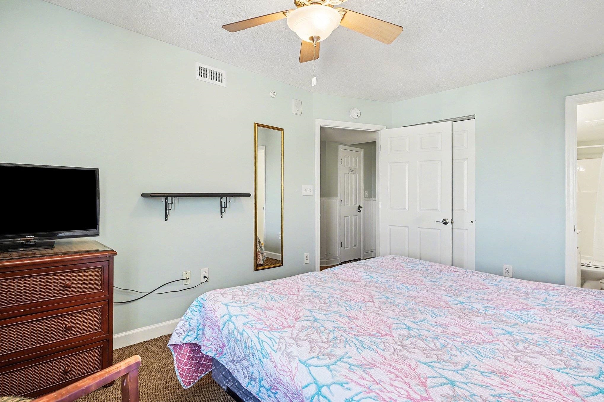 1707 Perrin Drive, Unit 701 North Myrtle Beach, SC 29582 - Photo 23 of 40 Bedroom with dark carpet, ceiling fan, a closet, ensuite bathroom, and a textured ceiling