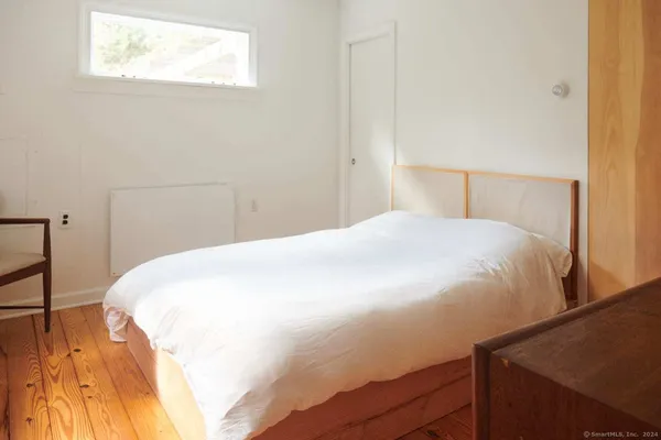 a large bed sitting in a bedroom next to a window