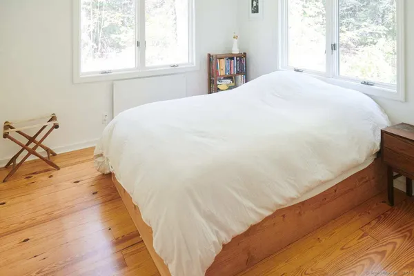 a large bed sitting in a bedroom next to a window