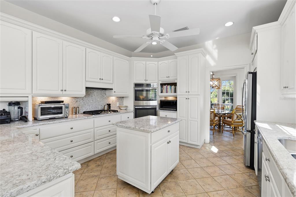 162 Blackwall Court Boca Grande, FL 33921 - Photo 21 of 62 a kitchen with kitchen island granite countertop a stove sink and cabinets