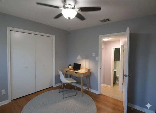 a view of a workspace with furniture and a window
