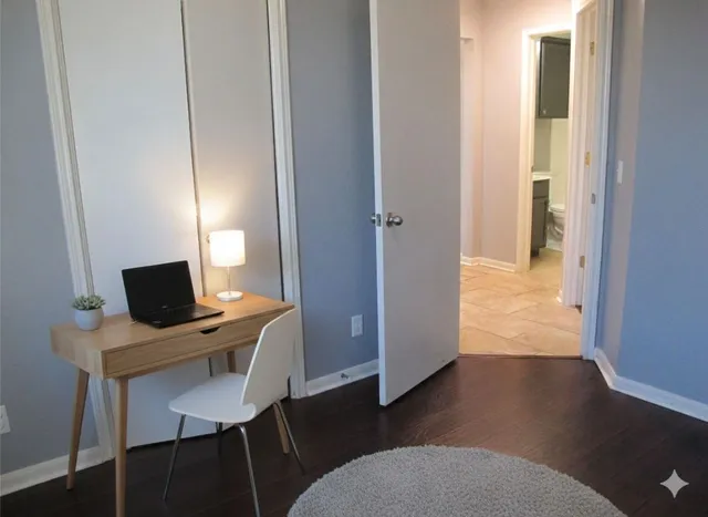 a view of a workspace with furniture and wooden floor